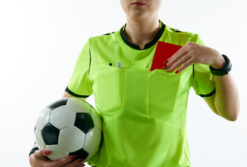 Young woman, female soccer referee holding ball, stopping game and showing red card against white...