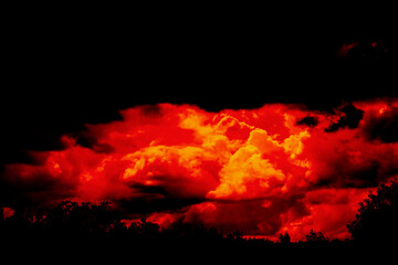 A crimson sunset with a looming thundercloud over the forest. Twilight hour. Selective focus.