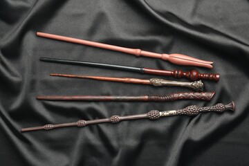 Different magic wands on black fabric, flat lay