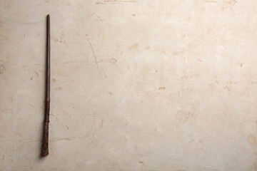 One magic wand on light textured background, top view. Space for text