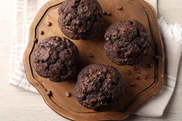 Delicious chocolate muffins on white wooden table, top view