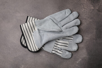 Pair of color gardening gloves on brown textured table, top view