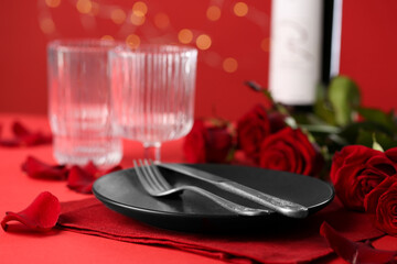 Fototapeta na wymiar Place setting with roses on red table, closeup. Romantic dinner