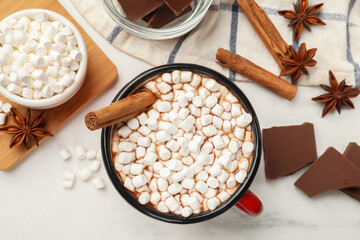 Tasty hot chocolate with marshmallows and ingredients on white marble table, flat lay