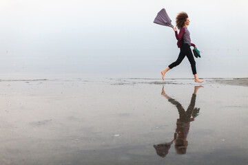Carefree Curly hair Woman Running on a Wet Beach Barefoot - Serenity People Concept