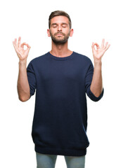 Naklejka premium Young handsome man wearing winter sweater over isolated background relax and smiling with eyes closed doing meditation gesture with fingers. Yoga concept.