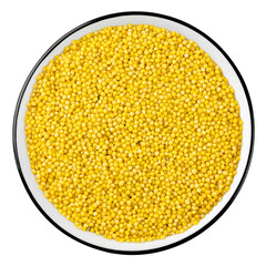 Top view of raw yellow millet grains in bowl isolated on white.