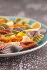 Colorful pasta background. Top view of five colors pasta shells .Heap of colorful spiral pasta,macaroni texture.