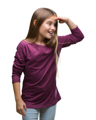 Fototapeta premium Young beautiful girl over isolated background very happy and smiling looking far away with hand over head. Searching concept.