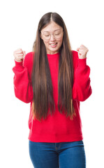 Obraz premium Young Chinese woman over isolated background wearing glasses excited for success with arms raised celebrating victory smiling. Winner concept.