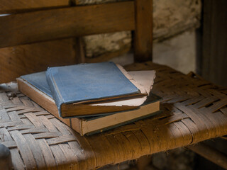 old books leaning on the seat of a chair