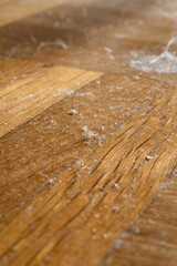 Small dust specs and fiber on wooden floor tiles. Macro close up shot, no people