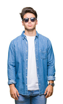 Young handsome man wearing sunglasses over isolated background skeptic and nervous, frowning upset because of problem. Negative person.