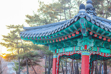 Close-up Korean traditional wooden pavilion with roof tiles at Woryeonggyo Park at sunset, next to the Wooden bridge at Andong, South Korea on autumn season. Korean architecture and Dancheong.