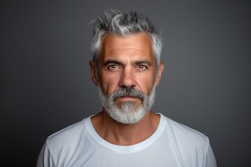 Portrait of a handsome mature man with gray hair and beard on grey background - obrazy, fototapety, plakaty