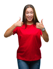 Young beautiful caucasian woman over isolated background success sign doing positive gesture with hand, thumbs up smiling and happy. Looking at the camera with cheerful expression, winner gesture.