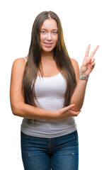 Young caucasian beautiful woman over isolated background smiling with happy face winking at the camera doing victory sign. Number two.