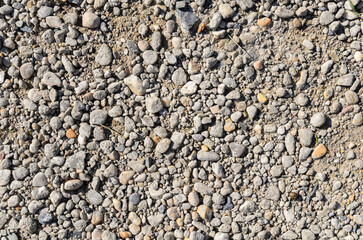 Abstract background with crushed gravel and small little grey rocks and stones, close-up view from...