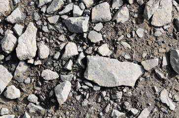 Abstract background with crushed gravel and small little grey rocks and stones, close-up view from directly above