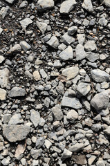 Abstract background with crushed gravel and small little grey rocks and stones, close-up view from directly above
