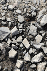 Abstract background with crushed gravel and small little grey rocks and stones, close-up view from directly above