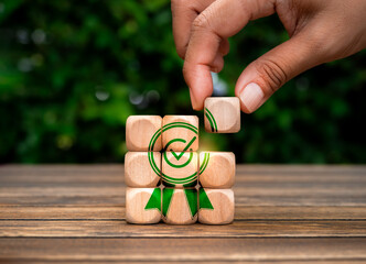 Business success and right award concept. Hand put last piece of small wooden cube block to...