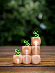 Green percentage and rise up arrows on wooden cube blocks as a business graph steps on table and...