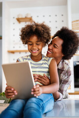 Happy african american single mother helping child with distance education. Online education