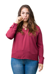 Beautiful plus size young woman over isolated background mouth and lips shut as zip with fingers....