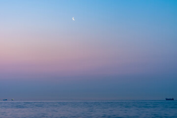 Obraz premium 夜明けの空の月と海の船20210310