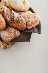Assorted bakery products including loafs of bread,  baguette and rolls in basket