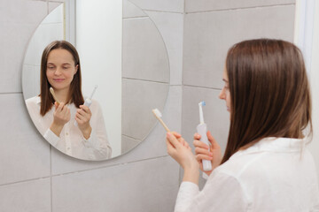 Choosing a toothbrush. Ideal toothbrush model. Electric vs. manual brushes. Caucasian young adult...