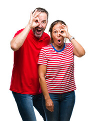 Middle age hispanic couple in love over isolated background doing ok gesture shocked with surprised...