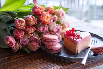 Beautiful pink roses and tulips with sweet pastrys. Concept background for mother's day,...