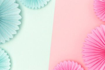 Border frame made of tissue paper fans in a pink and blue colors. Gender reveal party concept with copy space.