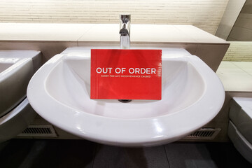 Elegant and modern wash basin with Out of Order signage placed below tap
