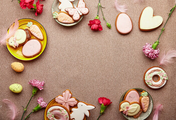 Spring Easter pastel background. Decorated aesthetic Easter cookies, pink flowers with feathers and eggs.