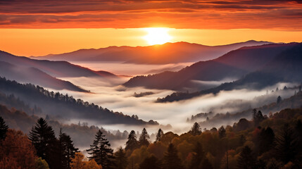 a smoky mountain sunset, where the sky is ablaze with warm tones as the sun bids farewell behind the peaks. The mountains are veiled in a delicate mist - obrazy, fototapety, plakaty