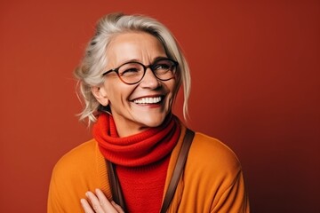 Portrait of a happy senior woman wearing glasses and a red scarf.