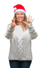 Middle age senior hispanic woman wearing christmas hat over isolated background showing and pointing up with fingers number six while smiling confident and happy.