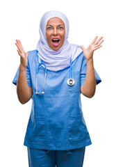 Middle age senior arab nurse woman wearing hijab over isolated background celebrating crazy and amazed for success with arms raised and open eyes screaming excited. Winner concept