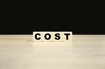 Cost word written on wooden blocks. Cost text for your desing, concept.