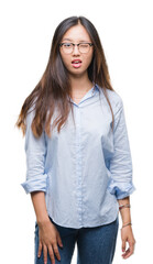 Young asian business woman wearing glasses over isolated background winking looking at the camera...