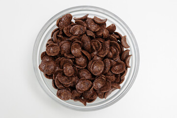Top view of choco cereals served in bowl on white