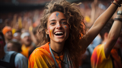 A girl in orange smiles in the crowd at the Holi festival.