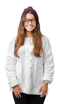 Young beautiful brunette hipster woman wearing glasses and winter hat over isolated background with a happy and cool smile on face. Lucky person.