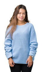 Young beautiful brunette woman wearing blue winter sweater over isolated background Relaxed with serious expression on face. Simple and natural looking at the camera.
