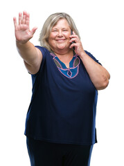 Senior plus size caucasian woman talking on the phone over isolated background with open hand doing stop sign with serious and confident expression, defense gesture