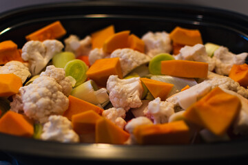 Raw vegetables cut into small pieces prepared for steaming, cauliflower, butternut, leek, carrot