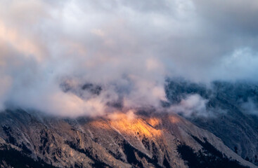 Sunrise light under clouds in the mountain peak